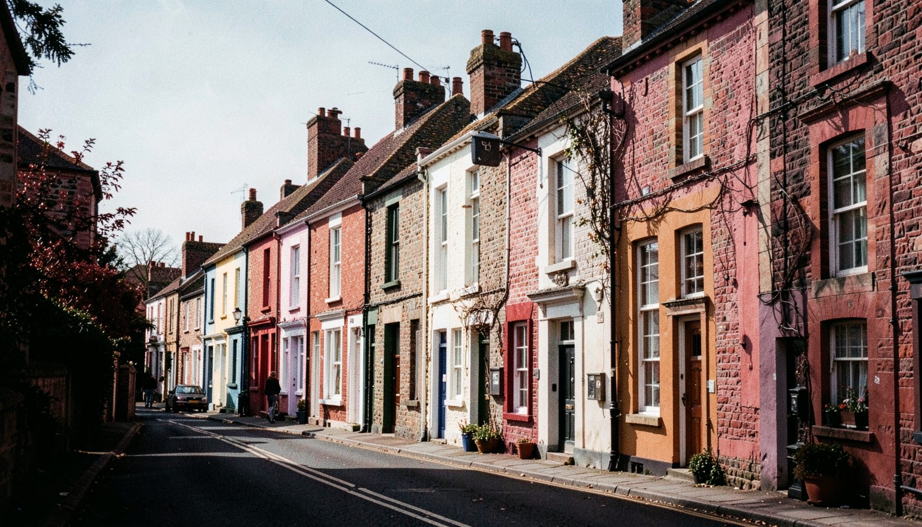 A row of colourful Georgian townhouses along a quiet Limerick street on a sunny afternoon